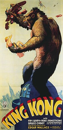 Promotional poster for King Kong showing the titular ape atop the Empire State Building holding a woman in one hand and an airplane in the other.